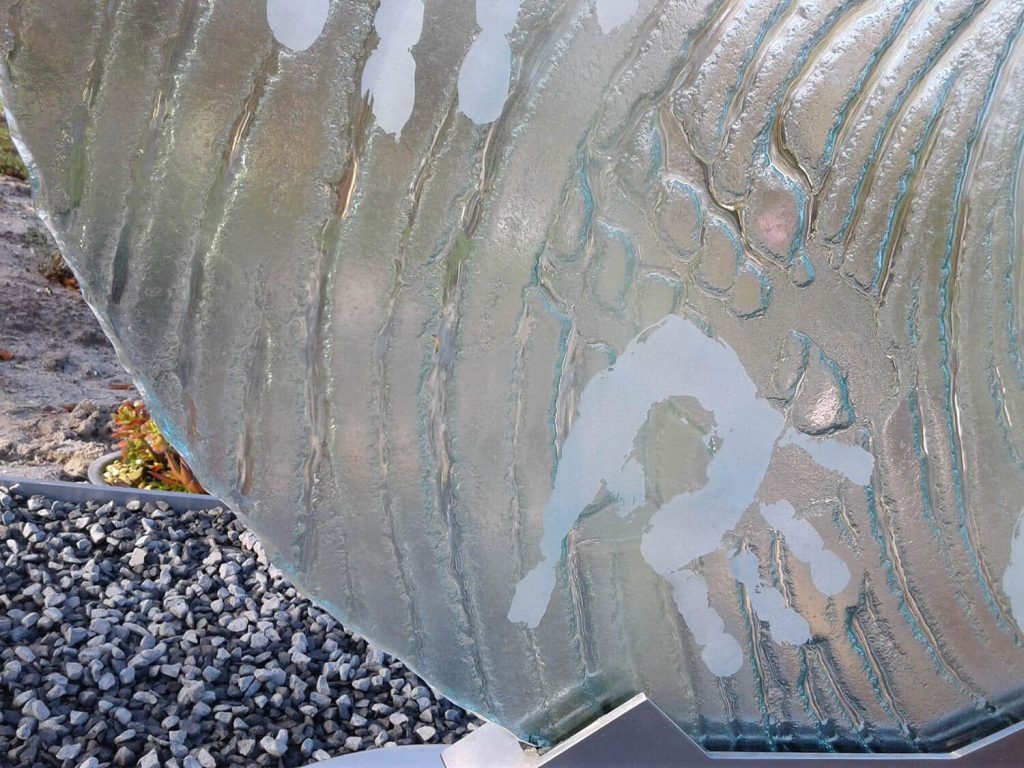 Detail van het glas grafmonument met verwerkte handafdrukken en kunstig design als eerbetoon